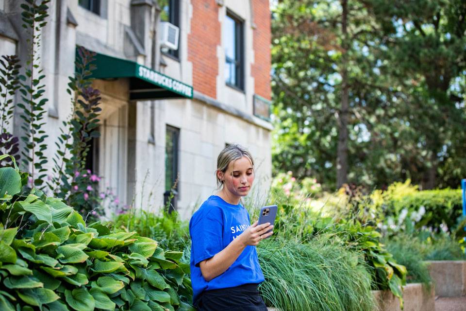 SLU student scrolling on their cell phone