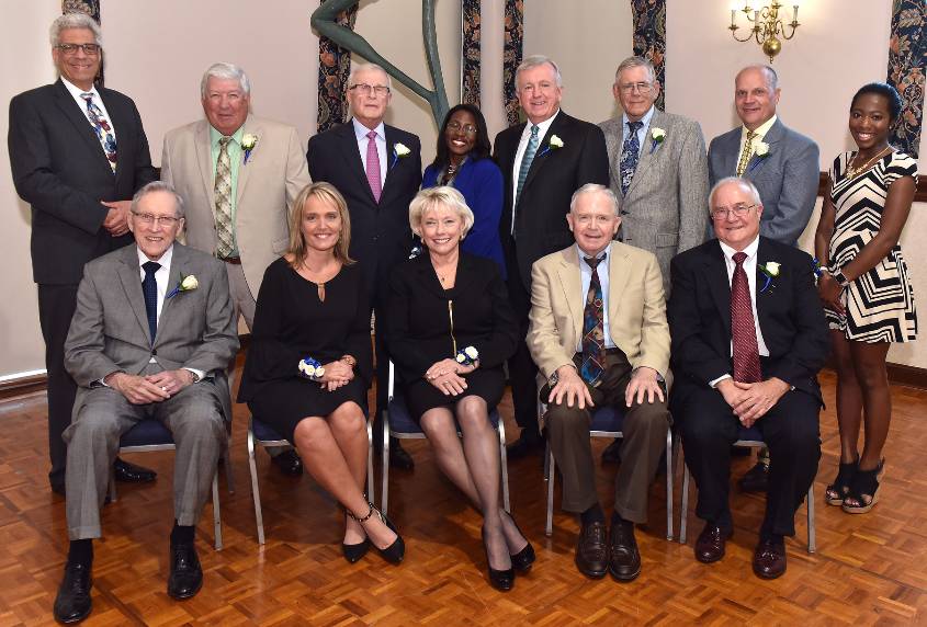 Winners pose in two rows, both seated and standing.