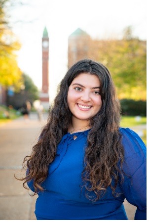 Krysta Couzi stands in front of the SLU clock tower