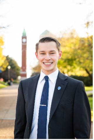 Darren Manion stands in front of the SLU clock tower