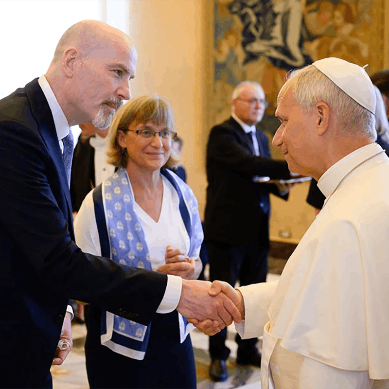 President Feser, standing next to his wife Kathy, shakes hands with the pope.