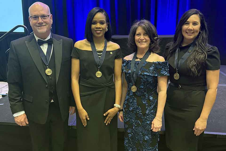 four people pose for a photo