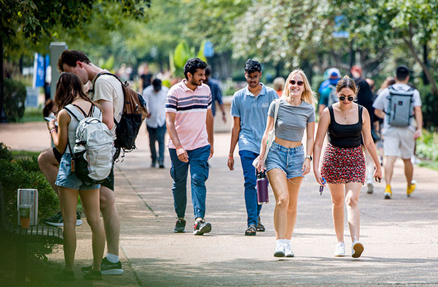 Two students walking together down a crowded pedestrian mall