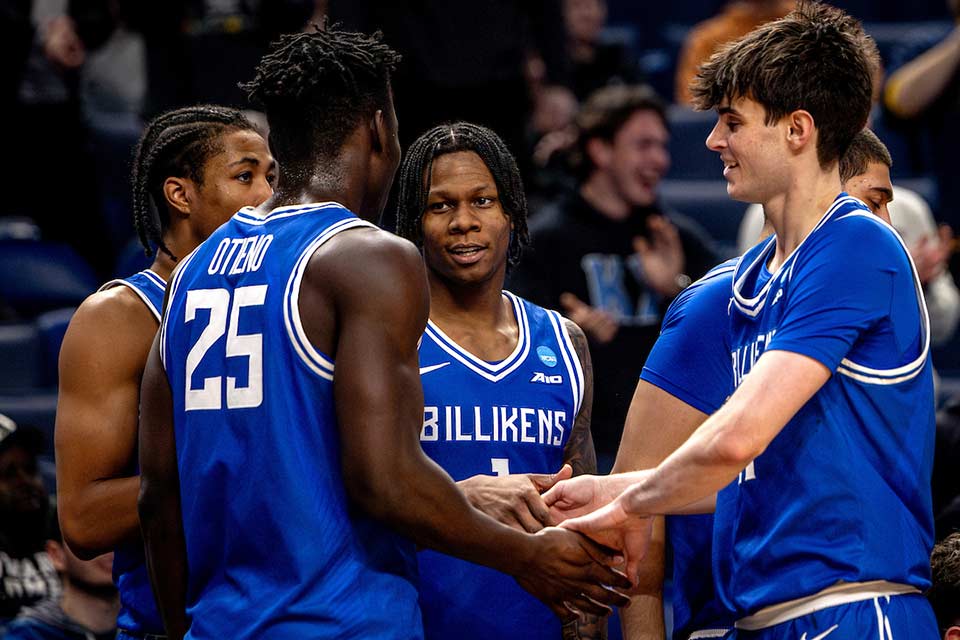 Members of the SLU Men's Basketball team congratulate each other following a win in the first round of the NCAA Championship