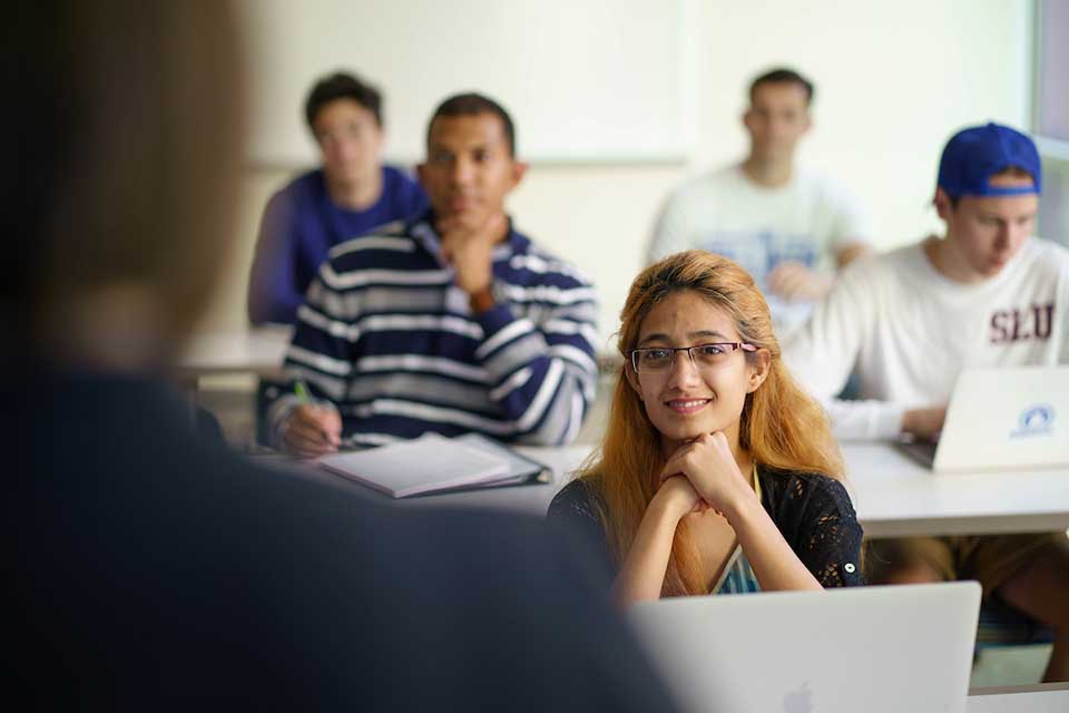 Students in a classroom with the shoulder of an instructor in the foreground